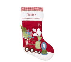 a red christmas stocking with a train on it's side and the name taylor