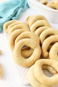 some cookies that are on a white plate and next to a bowl with nuts in it