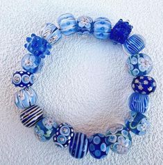 a bracelet made with blue glass beads and silver accents on a white carpeted surface