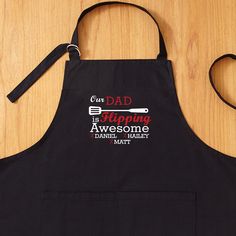 a black apron that says dad is flipping awesomely and has a spatula on it