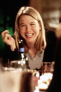 a smiling woman sitting at a table in a restaurant