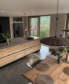 a kitchen with an island, table and chairs next to a window that looks out onto the valley