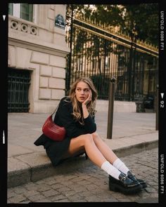 a woman sitting on the ground with her legs crossed