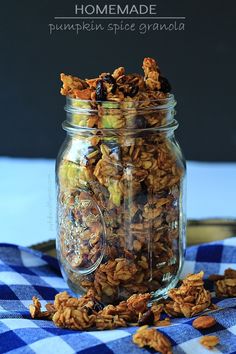 homemade pumpkin spice granola in a glass jar on a blue checkered tablecloth