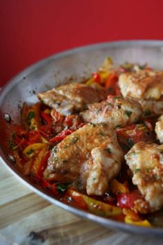 a pan filled with meat and vegetables on top of a wooden table