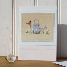 a card with an image of a watering can and a bird on it