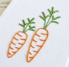 two carrots embroidered onto a white piece of paper