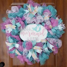 a wreath that says 30th mermaid sleepin on the front door with ribbons around it