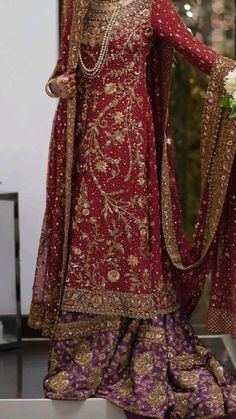 a woman in a red and gold bridal outfit