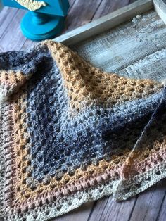 a crocheted blanket sitting on top of a wooden table