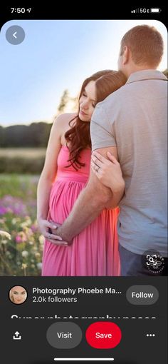 a man and woman standing next to each other in front of a field with flowers