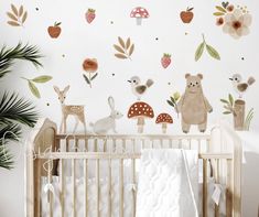 a baby's room with an animal wall decal and woodland animals on the wall