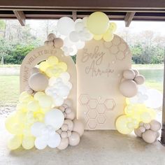 balloons and honeycombs decorate the entrance to a baby shower