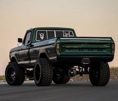 a green truck is driving down the road