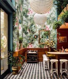 the interior of a tropical themed restaurant with checkered flooring and bar stools