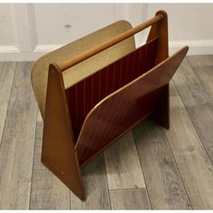 an old wooden magazine holder sitting on the floor