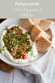 a white plate topped with pita bread and garnished with herbs on top