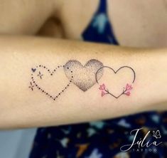 three hearts tattoo on the arm with dots and stars around them, all in different colors