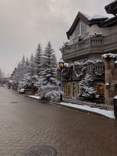 a street with snow covered trees and buildings