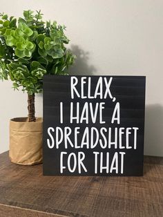 a sign that says relax i have a spreadsheet for that next to a potted plant