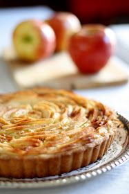 an apple tart sitting on top of a table next to some apples and cheese