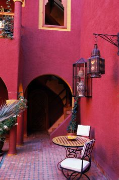 a pink building with a table and chairs