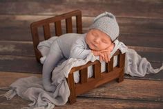 a newborn baby is sleeping in a wooden crib