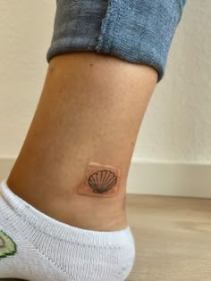 a woman's foot with a small tattoo on the side of her leg,