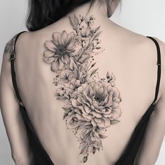 the back of a woman's neck with flowers on it