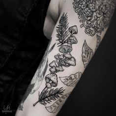 a woman's arm with tattoos on it and flowers in the middle of her arm