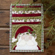 a quilted christmas ornament hanging from a pine tree