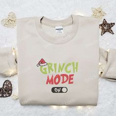 Grinch Mode On Embroidered Sweatshirt, Christmas Embroidered T-shirt, Best Christmas Gift Ideas Nestled in the heart of holiday fashion, Tinicloset beckons you to explore a world of captivating custom embroidered apparel that will elevate your festive spirit to new heights. As the season of joy approaches, we extend our warmest invitation to discover our exquisite collection of custom embroidered shirts, sweatshirts, T-shirts, and hoodies, each piece meticulously designed to awaken your curiosit Casual Christmas Tops With Embroidered Graphics, Casual Embroidered Christmas Top, Holiday Cotton Top With Embroidery, Holiday Cotton Embroidered Tops, Embroidered Christmas Holiday Tops, Festive Embroidered Crew Neck Top, Holiday Embroidered Tops As Gift, Christmas Cotton Top With Embroidered Text, Holiday Embroidered Cotton Top