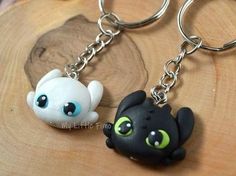 two key chains that have different colored eyes on them, one is black and the other is white