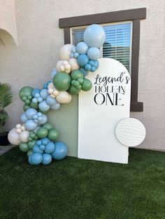 a balloon arch in front of a building with balloons on it and a sign that says legend's today is one