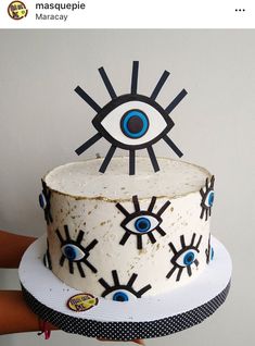 someone is holding up a cake with an evil eye on it