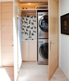 a washer and dryer in a room with wooden floors, walls and cabinets