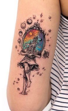 a woman's arm with a tattoo on it that has an image of a castle inside