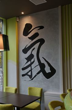 a restaurant with green chairs and a large painting on the wall