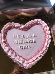 a cake in the shape of a heart that says hell is a teenage girl