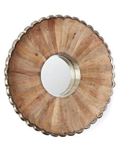 a mirror that is sitting on top of a wooden shelf with metal trimmings