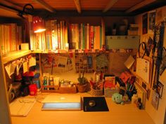 a cluttered desk with many books on the shelves and other items in front of it