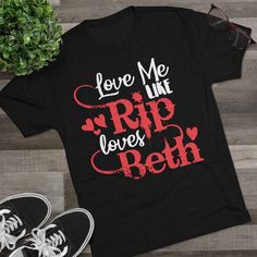 "✦Product Name: Love Me Like Rip Loves Beth ✦Materials: 50% polyester, 25% combed ring-spun cotton, 25% rayon   ✦Color: 7 Colors Available  ✦Size: S, M, L, XL, 2XL ✦Pre-Shrunk: Yes ✦Singles: 32 ✦Tear Away Label: Yes  ✦Weight: 4.3 Oz/y2 (146 g/m2) ✦True to Size: Yes  ✦Shoulder Taping: Yes ✦Machine Washable: Yes ✦Package: 1x Unisex Shirt Attention Yellowstone fans of the world, if you are looking for the perfect graphic tee, then you came to the right place. \"Love Me Like Rip Loves Beth\" graphic tee is a guaranteed show stopper. You will be the envy of all the Yellowstone fans around town. This fitted t-shirt is a staple in many women's wardrobe collections. It's soft, form-fitting, and pre-shrunk, so it will maintain its shape after washing.    The chic shirt with western style makes your Yellowstone Tv Show, Rip Love, Yellowstone T Shirts, Ripped Shirts, Beth Dutton, Rose Shirts, Chic Shirts, Love Me Like, Women's Wardrobe