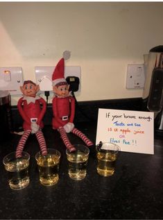 two elfs sitting next to each other on a counter with drinks in front of them