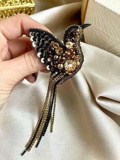 a person holding a bird brooch in their hand