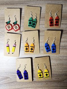 six small earrings made out of legos on top of a piece of cardboard paper