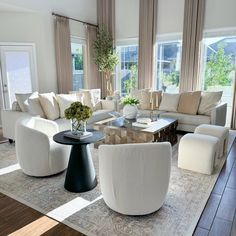 a living room filled with white furniture and lots of window sill space in front of the couches