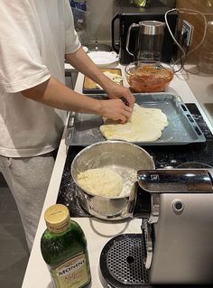 a man is making pizzas in the kitchen