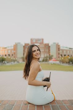 a woman in a white dress sitting on the ground