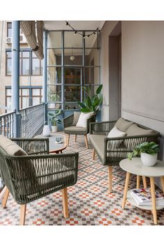 an outdoor patio with wicker furniture and potted plants on the balcony railings