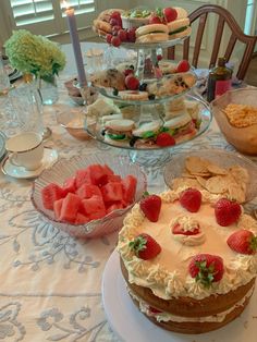 a table topped with lots of cakes and desserts next to plates of food on top of a table